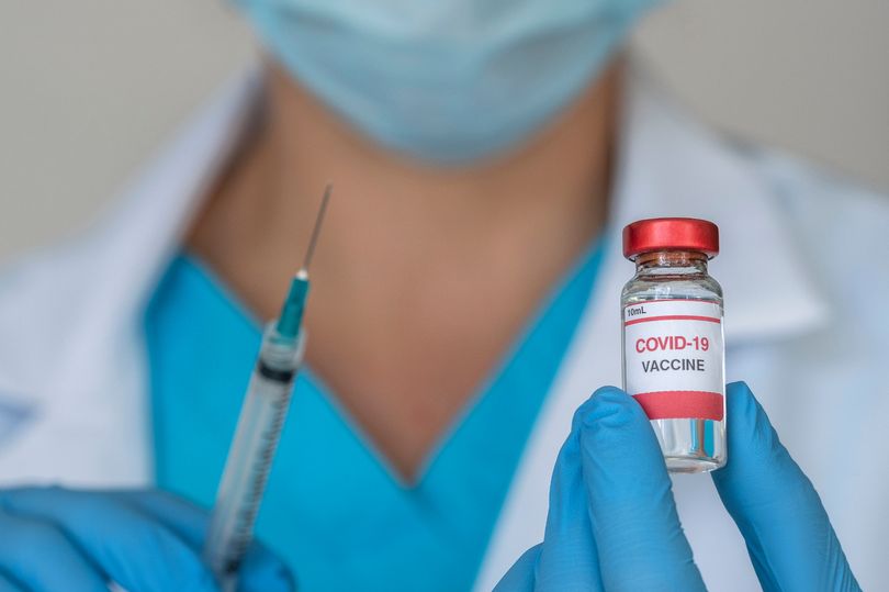 0_Close-up-of-doctors-hands-holding-Covid-19-vaccine-and-syringe.jpg